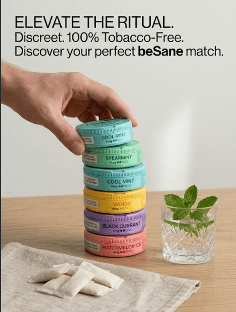 A hand stacking BeSane tins in six flavours beside loose pouches and a glass of mint